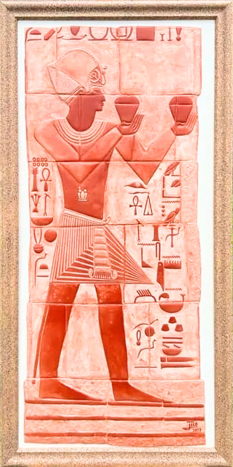 The Temple: a framed raised relief in terracotta clay on wood, a figure making an offering beside carved hieroglyphs